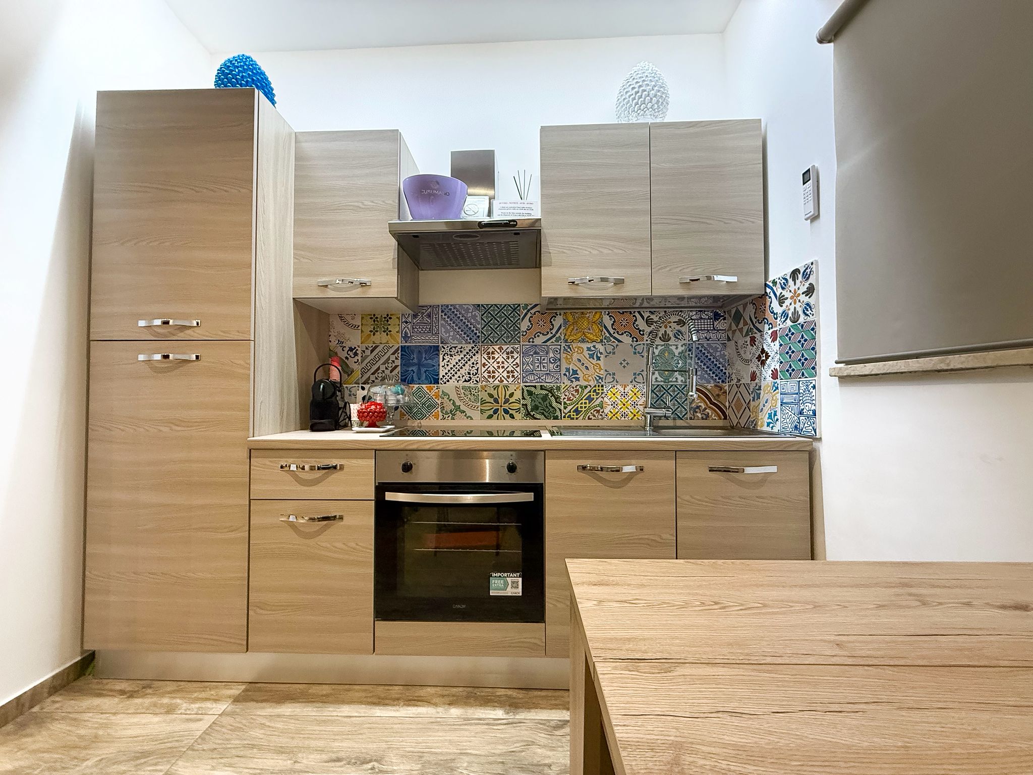 Parete attrezzata con cucina a induzione, forno e frigorifero